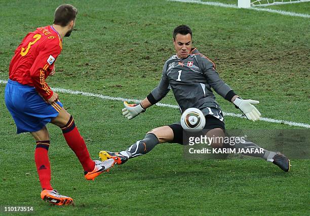 Switzerland's goalkeeper Diego Benaglio saves the ball as Spain's defender Gerard Pique tries for a chance on goal during their Group H first round...