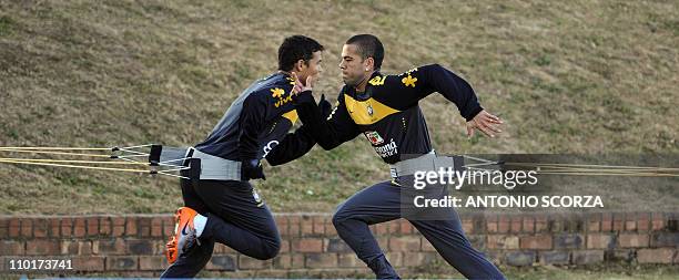 Brazil's national football team Daniel Alves and Thiago Silva warm up during a training session at Randburg High School on June 16, 2010 in...