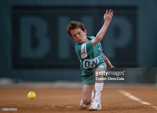 Ballboy passes down a tennis ball along the court at the French Open Tennis Championship on 1st June 1987 at the Stade Roland Garros Stadium in...