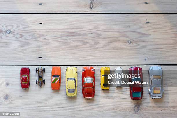 toy cars lined up in a row on floor - konkurrenz stock-fotos und bilder