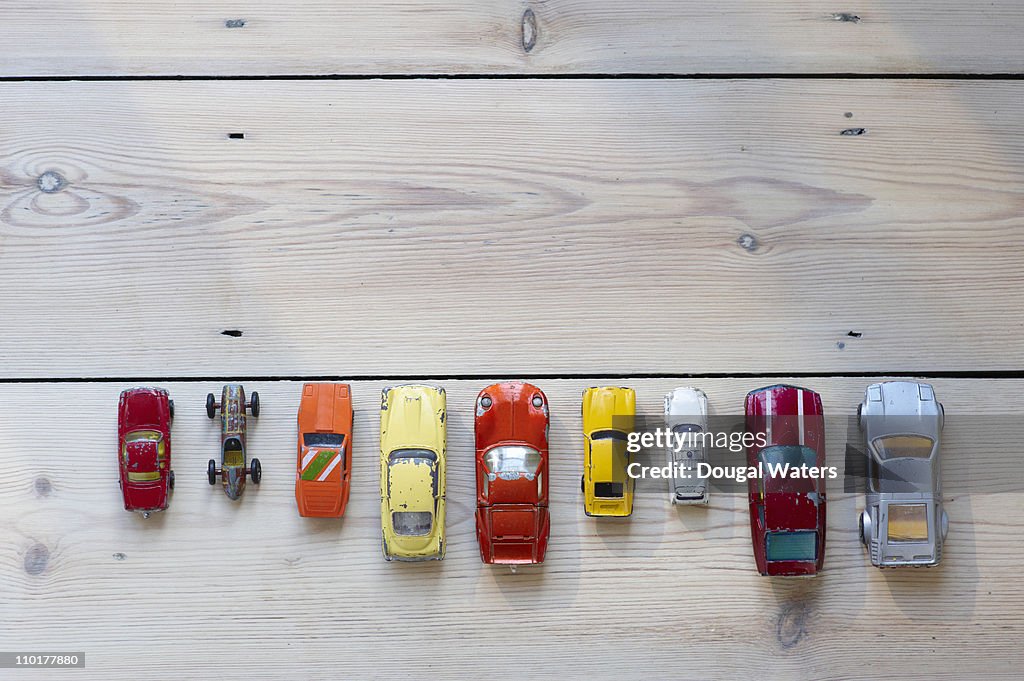 Toy cars lined up in a row on floor