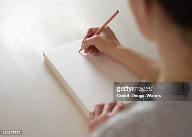 woman about to draw on blank pad of paper - escritor fotografías e imágenes de stock