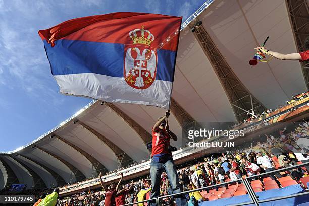 Serbian supporter waves a national falg at the end of the Group D first round 2010 World Cup football match Germany vs. Serbia on June 18, 2010 at...