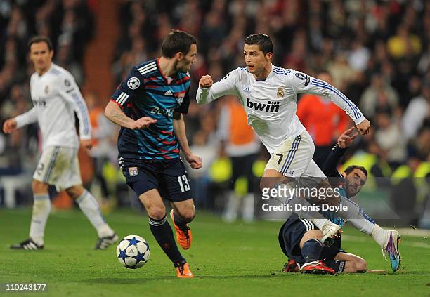 Cristiano Ronaldo of Real Madrid tries to dribble past Anthony Reveillere of Lyon during the UEFA Champions League round of 16 second leg match...