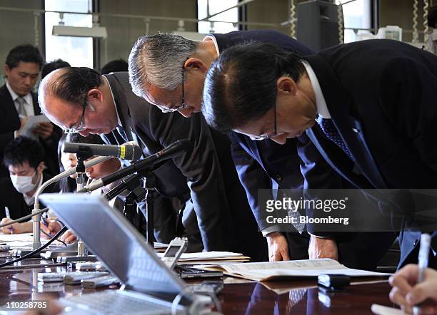 Satoru Nishibori, president of Mizuho Bank Ltd., center, bows during a news conference in Tokyo, Japan, on Thursday, March 17, 2011. Nishibori said...