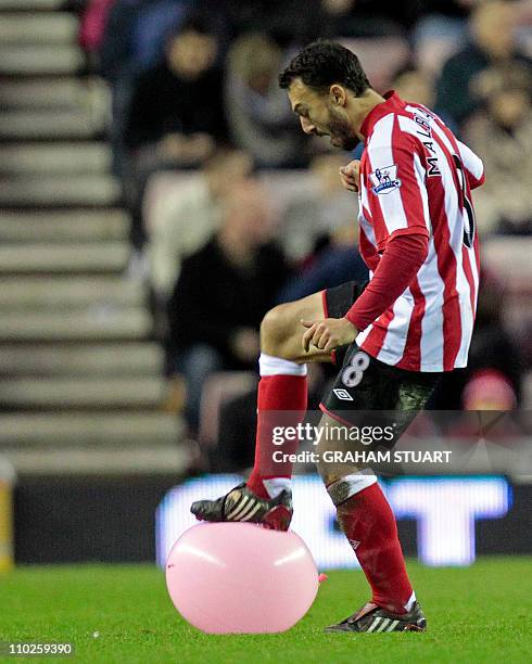 Sunderland's French midfielder Steed Malbranque bursts a balloon on the pitch during the English Premier League football match between Sunderland and...