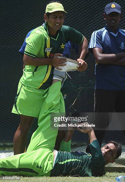 Shoaib Akhtar of Pakistan who has announced his retirement from international cricket has his leg stretched by a physio during a nets session at the...