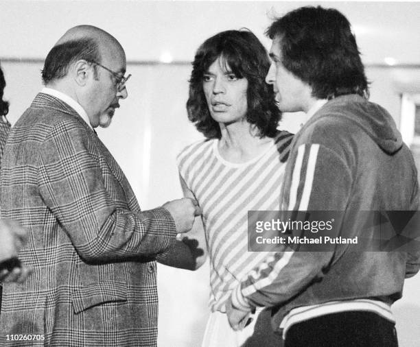 Ahmet Ertegun, head of Atlantic Records, talks to Mick Jagger and Peter Rudge, backstage at a Rolling Stones concert at Earls Court, London, May 1976.