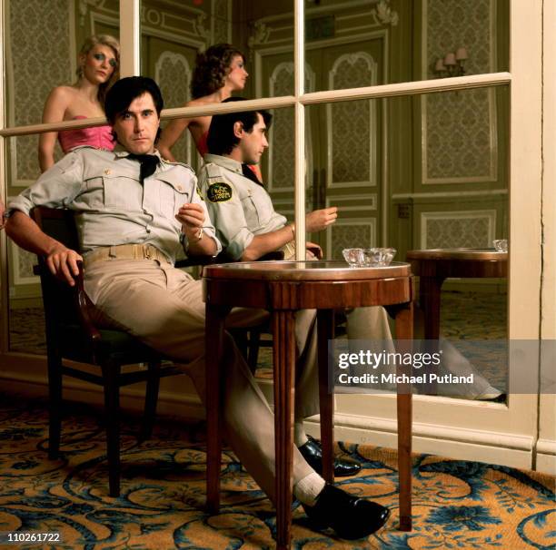 Bryan Ferry of Roxy Music, portrait, wearing military style uniform at the Montcalm Hotel, London, 31st October 1975. Reflected in the mirror are...