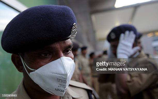 India's National Disaster Response Force personnel wearing face masks enter the international arrivals gate at the Indira Gandhi International...