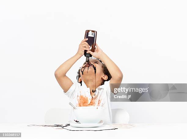 boy eating chocolate sauce - boy holding picture cut out stock-fotos und bilder