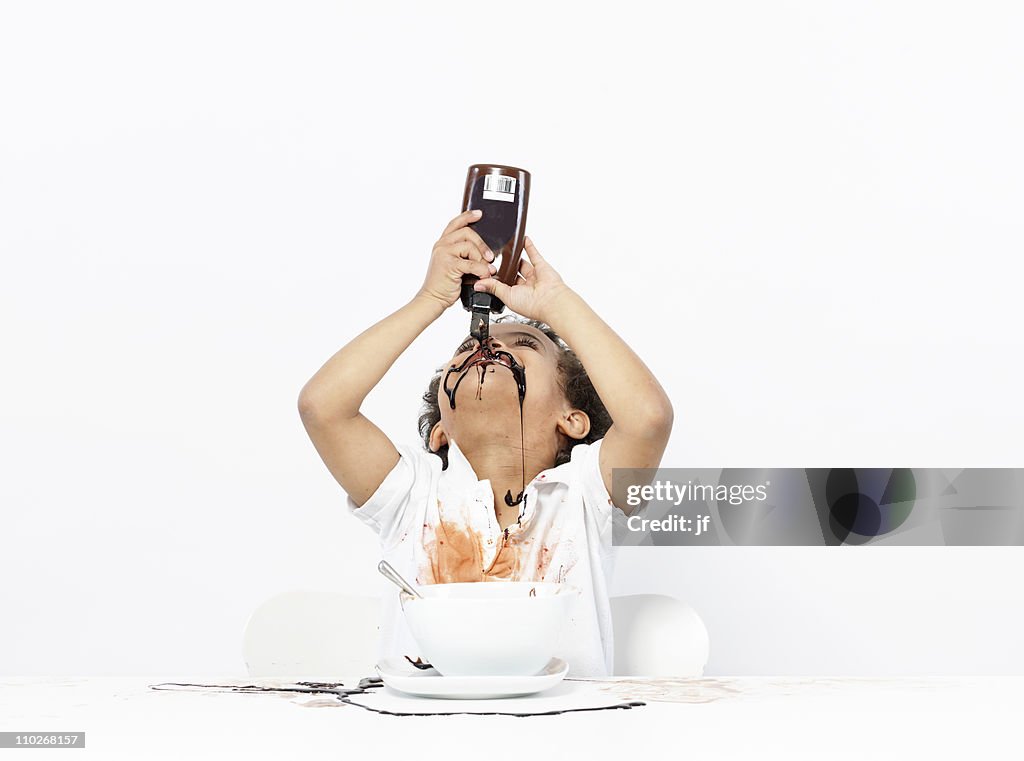 Boy eating chocolate sauce