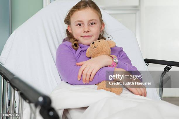 ill girl with toy in bed, smiling - hospital gurney stock pictures, royalty-free photos & images