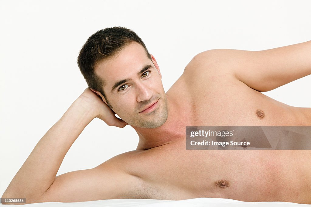 Portrait of young man resting on elbow