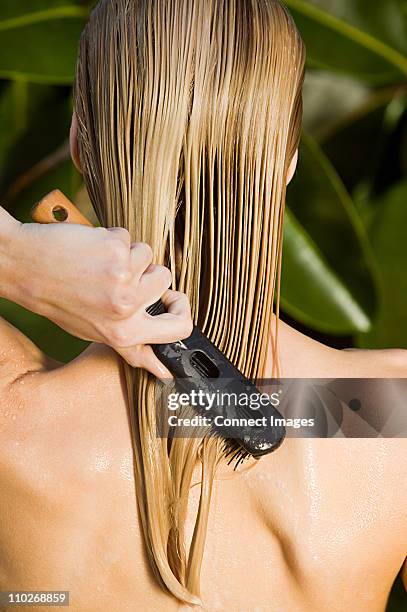 young woman brushing wet hair - cabello largo fotografías e imágenes de stock