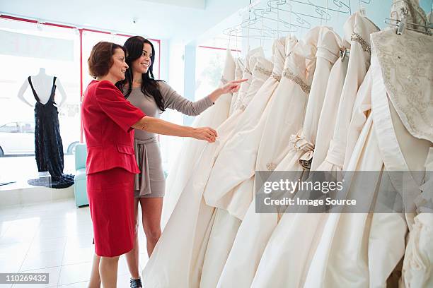 mother and daughter looking at wedding dresses - wedding dress store stock pictures, royalty-free photos & images