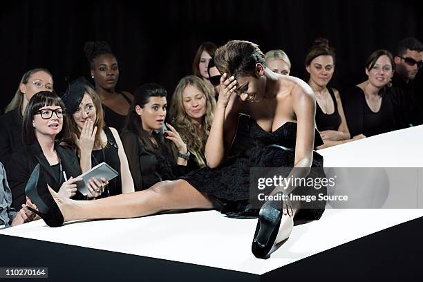 model sitting on catwalk having fallen down at fashion show - fall fashion event bildbanksfoton och bilder