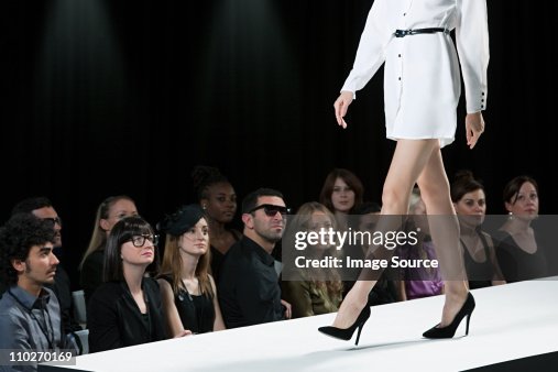 Audiencia ve modelo en pasarela en el desfile de moda, bajo la sección Audiencia ve modelo en pasarela en el desfile de moda, bajo la sección