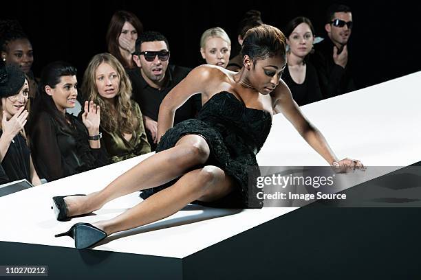 model sitting on catwalk having fallen down at fashion show - 2011 stage 19 stock pictures, royalty-free photos & images