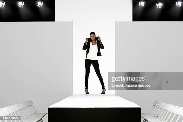 model with black leather jacket on catwalk at fashion show - fashion show stockfoto's en -beelden