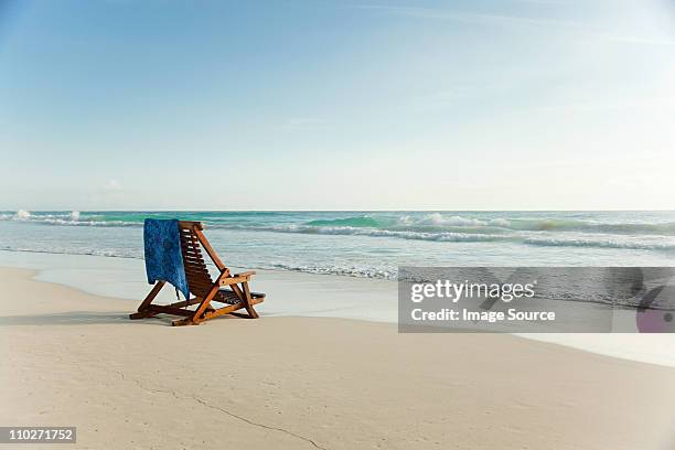 liegestuhl am sandstrand im water's edge " - beach deck chairs stock-fotos und bilder