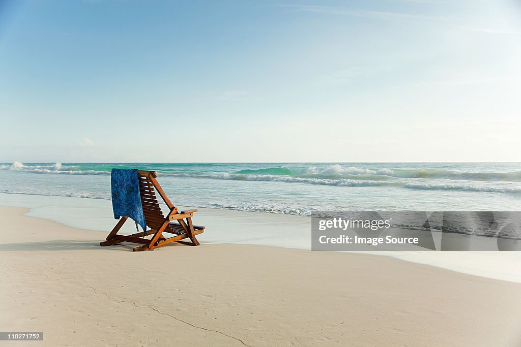Silla reclinable en la playa de arena en water's edge