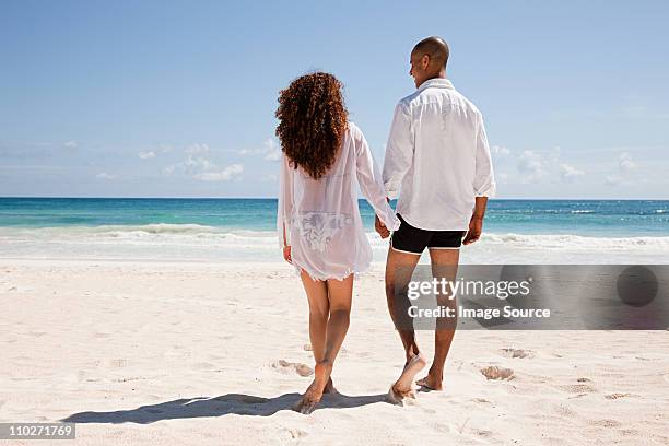 couple walking on sandy beach - indian honeymoon couples stock pictures, royalty-free photos & images