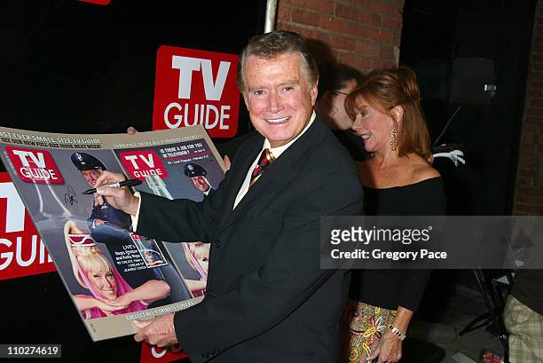 Regis Philbin signs a large poster copy of his TV Guide cover in which he is dressed as Major Nelson from "I Dream of Jeannie"