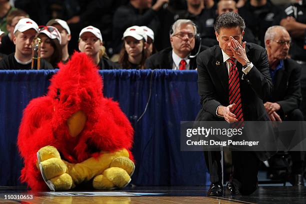 Head coach Rick Pitino of the Louisville Cardinals and the teams mascot react after a play while playing against the Morehead State Eagles during the...