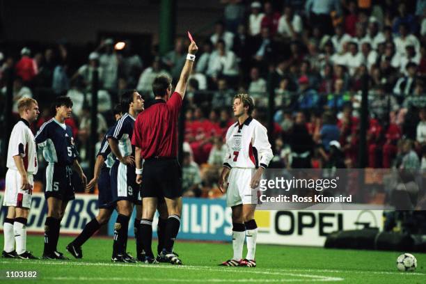 David Beckham of England is sent off by referee Kim Nielsen after lashing out at Diego Simeone of Argentina during the World Cup second round match...