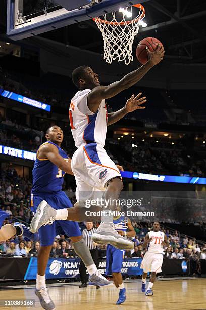 Erving Walker of the Florida Gators drives for a shot attempt against Orlando Johnson of the UC Santa Barbara Gauchos during the second round of the...