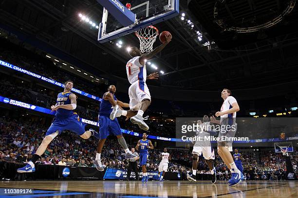 Erving Walker of the Florida Gators drives for a shot attempt against Orlando Johnson of the UC Santa Barbara Gauchos during the second round of the...