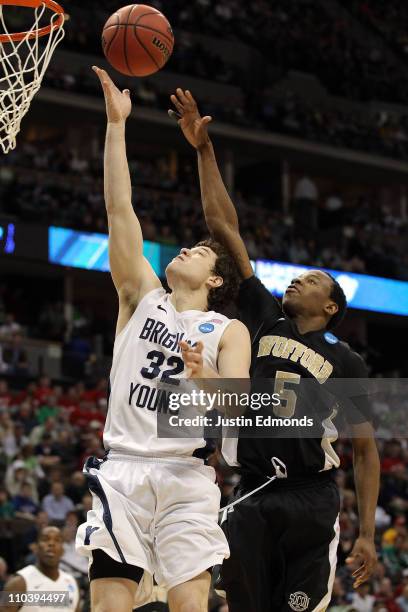 Jimmer Fredette of the Brigham Young Cougars goes to the hoop against Jamar Diggs of the Wofford Terriers during the second round of the 2011 NCAA...