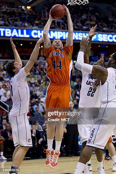 Bucknell forward Joe Willman puts up a shot amid three Connecticut defenders during second-half action in the second round of the 2011 NCAA men's...