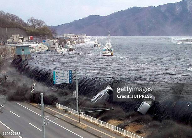 DATEThis picture taken by a Miyako City official on March 11, 2011 and released on March 18, 2011 shows a tsunami breeching an embankment and flowing...