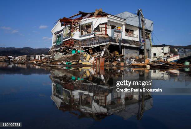 Toyoki Sugawara looks out from his destroyed liquor shop where he is collecting the items he can salvage on March 18, 2011 in Kesennuma, Miyagi,...