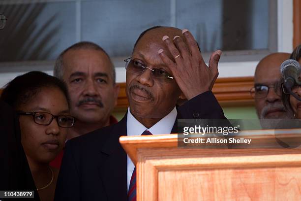 Former Haitian President Jean-Bertrand Aristide wipes his brow before a press conference after landing at the airport March 18, 2011 in...