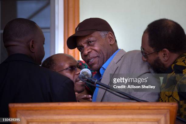 Former Haitian President Jean-Bertrand Aristide confers with actor Danny Glover after a press conference after landing at the airport March 18, 2011...