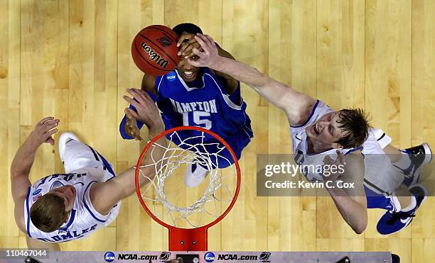 Wesley Dunning of the Hampton Pirates grabs a rebound between Mason Plumlee and Kyle Singler of the Duke Blue Devils during the second round of the...
