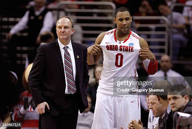 Jared Sullinger of the Ohio State Buckeyes holds his jersey out as head coach Thad Matta looks on late in the game against the Texas-San Antonio...