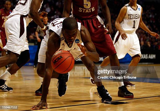 Texas A&M's Naji Hibbert struggles with the ball against Florida State's Bernard James during a second-round game in the 2011 NCAA men's basketball...