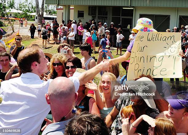Prince William shakes hands with Jane Machan who made a sign for Prince William at the Cardwell Community Hall on March 19, 2011 in Cardwell,...