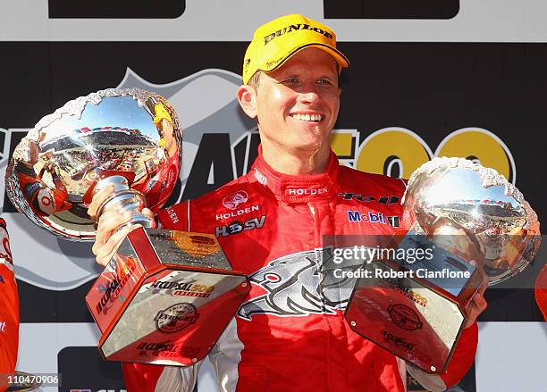 Garth Tander driver of the Toll Holden Racing Team Holden holds the winners trophies after winning race three for the Clipsal 500, which is round two...