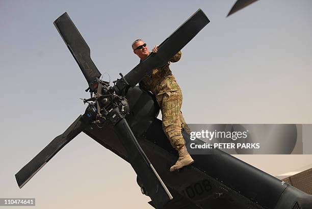 Army pilot from Company C, 1st Battalion, 52nd Aviation Regiment, MEDEVAC unit checks the tail rotor of his Blackhawk helicopter at Kandahar airfield...
