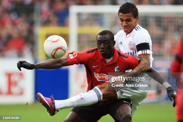 Papiss Demba Cisse of Freiburg is challenged by Luiz Gustavo of Muenchen during the Bundesliga match between SC Freiburg and Bayern Muenchen at...