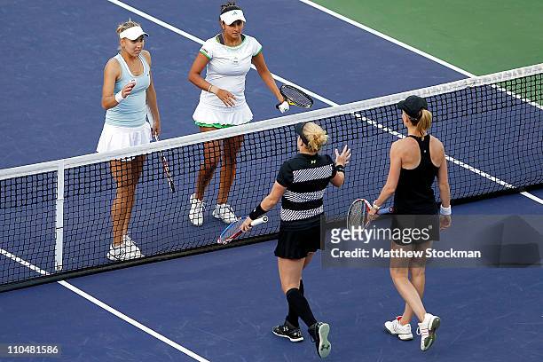 Elena Vesnina of Russia and Sania Mirza of India are congratulated at the net by Bethanie Mattek-Sands and Meghann Shaughnessy during the doubles...