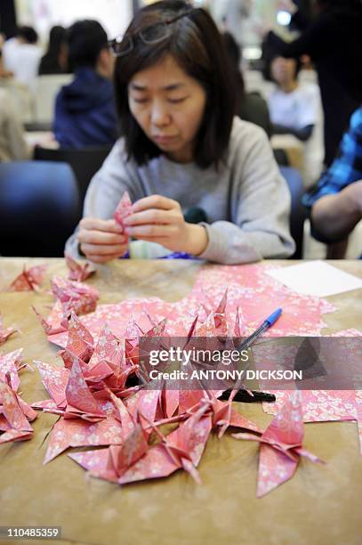 Participant folds an origami crane, part of 5000 that were to be folded for a donation drive for victims of the recent Japan earthquake and tsunami,...