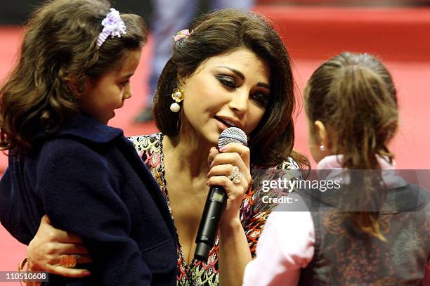 Lebanese pop star Haifa Wehbe sings with children during an event celebrating mother's day in Beirut on March 21, 2011. AFP PHOTO/STR