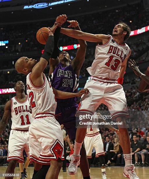 Joakim Noah of the Chicago Bulls blocks a shot by Jason Thompson of the Sacramento Kings as teammate Taj Gibson also defends at the United Center on...