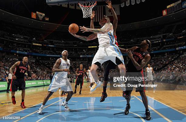 Chris Andersen of the Denver Nuggets lays up a shot in front of Reggie Evans of the Toronto Raptors at the Pepsi Center on March 21, 2011 in Denver,...